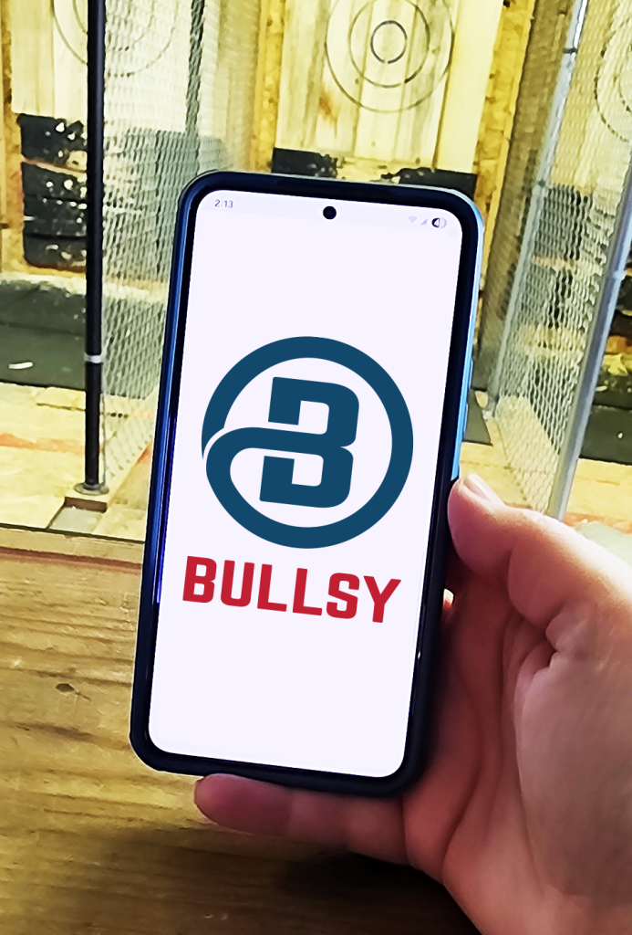 Bullsy app on a phone in someone's hand at an axe throwing venue