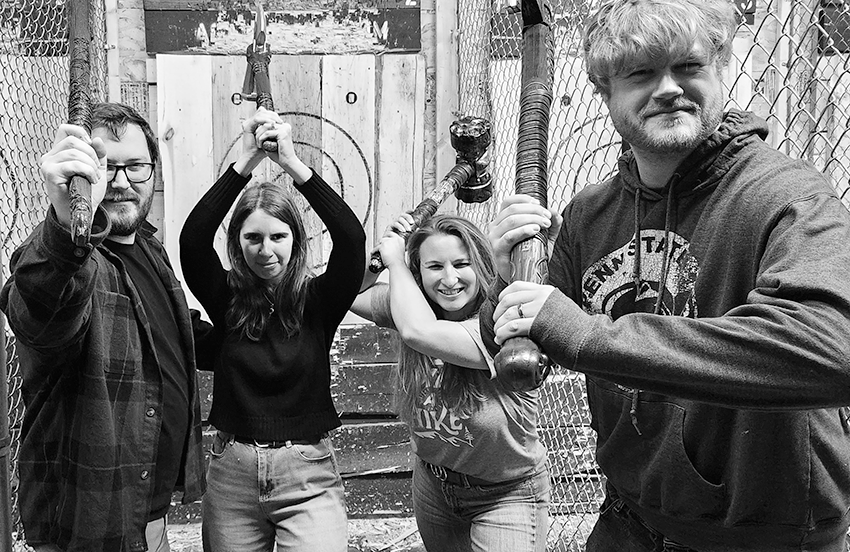 Four axe throwers posing for a photo
