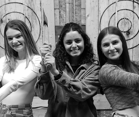 Three girls axe throwing at the Agawam Axe House. Photo by Anneliese Townsend