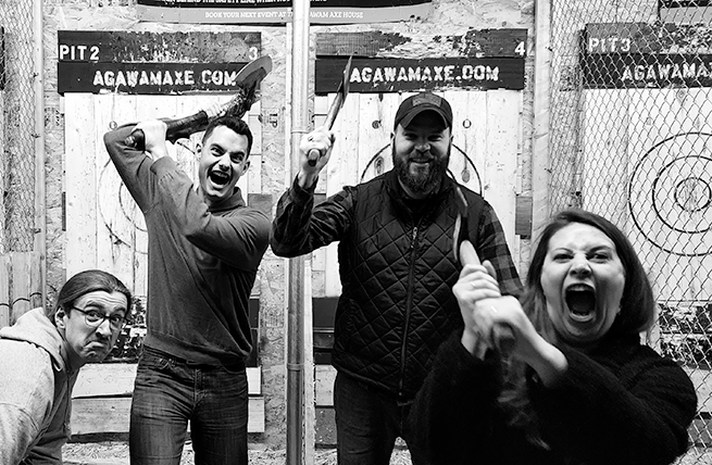 A group of axe throwing having fun using the Bullsy App axe throwing scoring.
